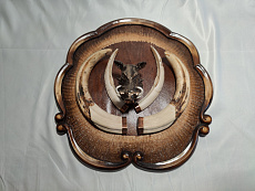 Клыки кабана на резном медальоне